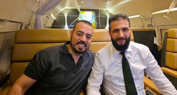 Muhenned Fayiz Misrî (çep) ligel Ehmed Şera di balafira ji Emîrtiyên Erebî yên Yekbûyî bo Sûriyê de, Nîsana 2025an.