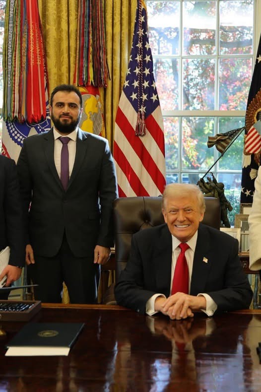 Qutaiba Qadish (de pie) con Donald Trump en el Despacho Oval durante la visita de la delegación siria, noviembre de 2025.